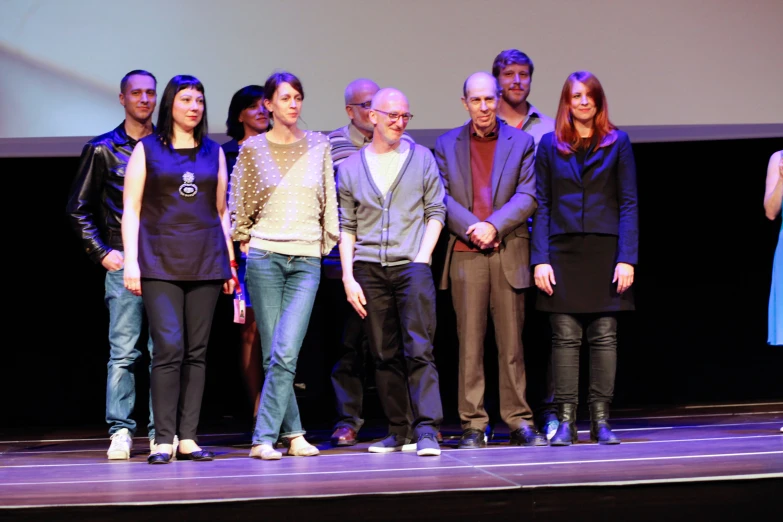 a group of people are standing on a stage