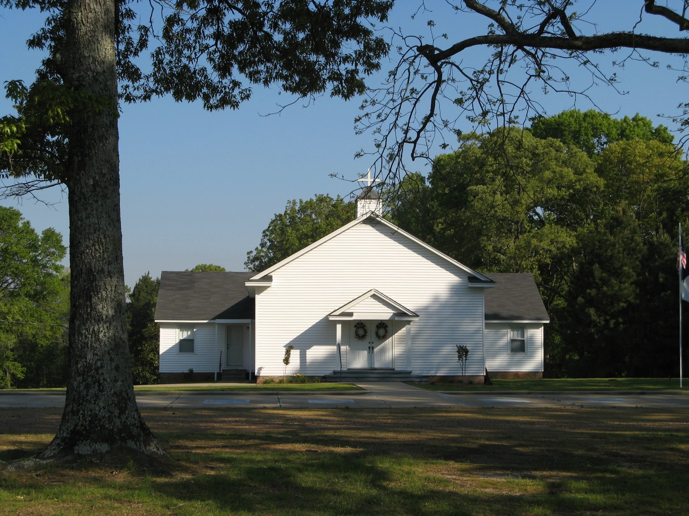 the house is on the corner with a tree in front