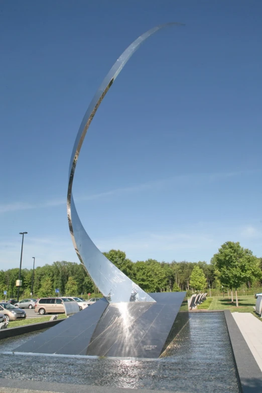 a large water fountain with a large curved object