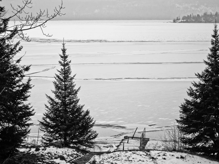 the snow covered landscape is next to the water