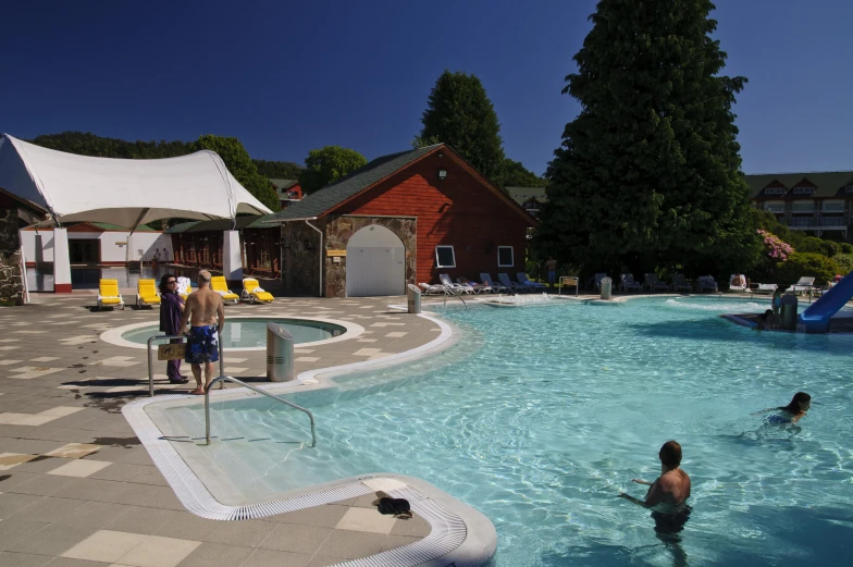 people play in a heated pool outside of a lodge