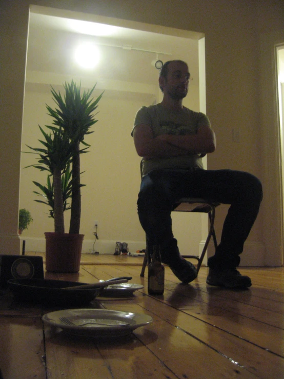 a person sitting on a chair with a plant in the background