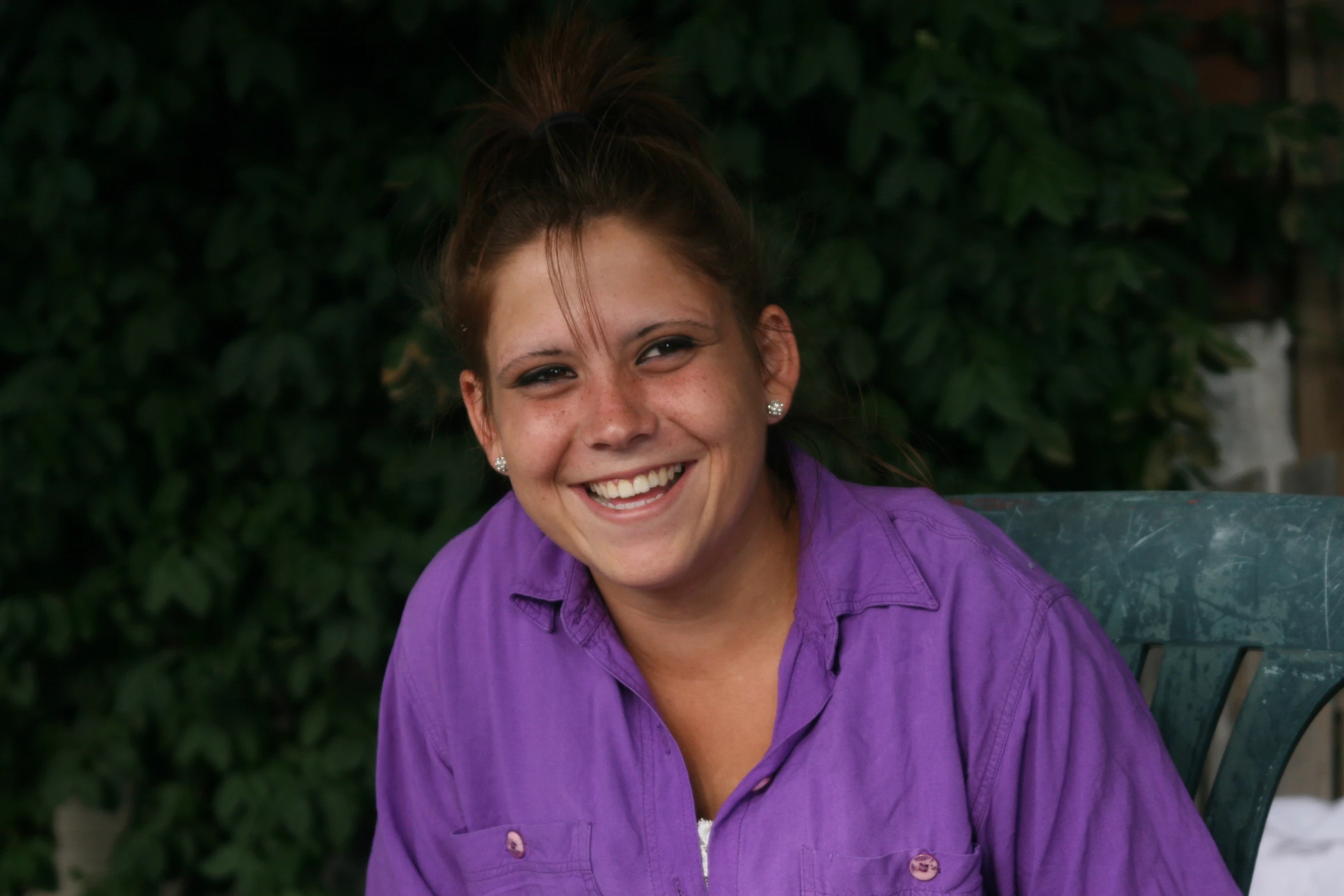 the young woman smiles for the camera while sitting