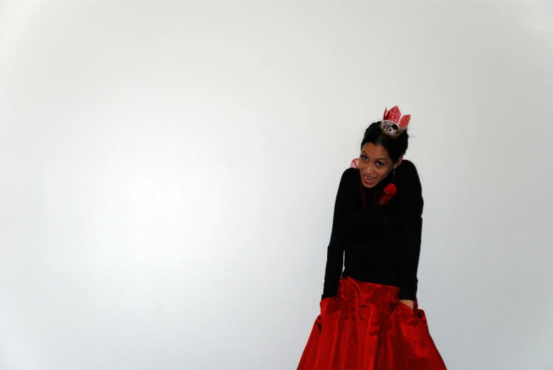 a girl wearing a red skirt standing against a white background