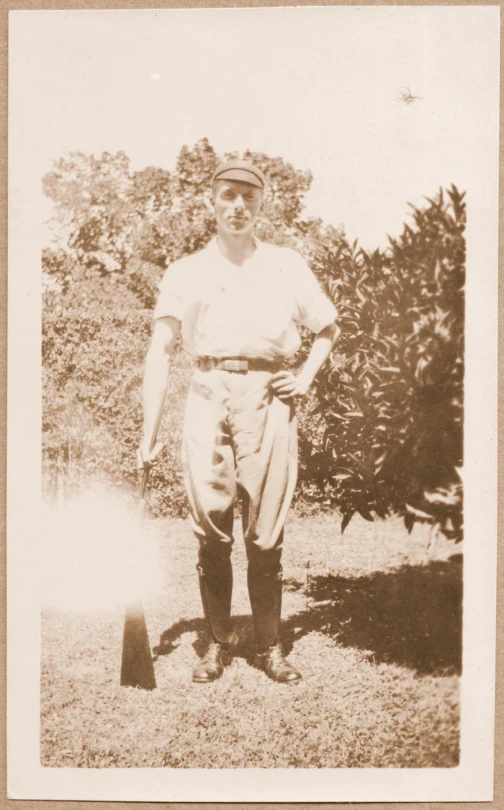 an old black and white pograph shows a man in baseball uniform