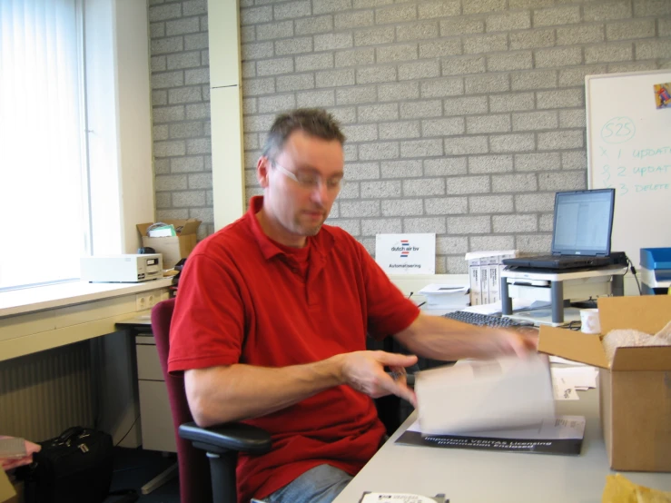 a man is looking over a paper on the desk