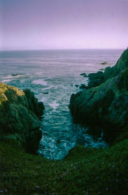 a lighthouse overlooks the ocean from green cliffs