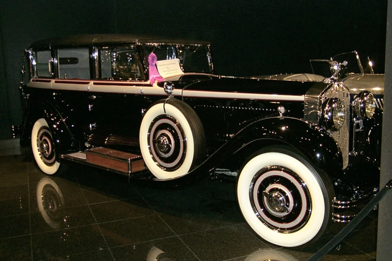 an antique car is parked with the wheels and fenders down