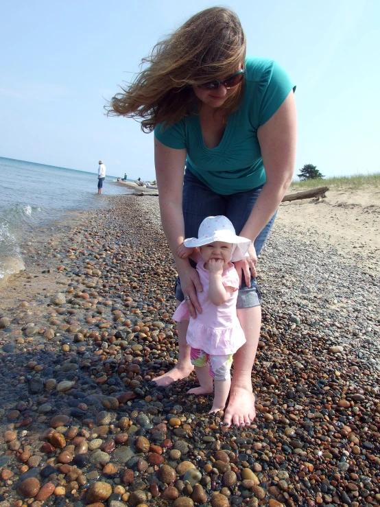 a woman and her child are on a beach