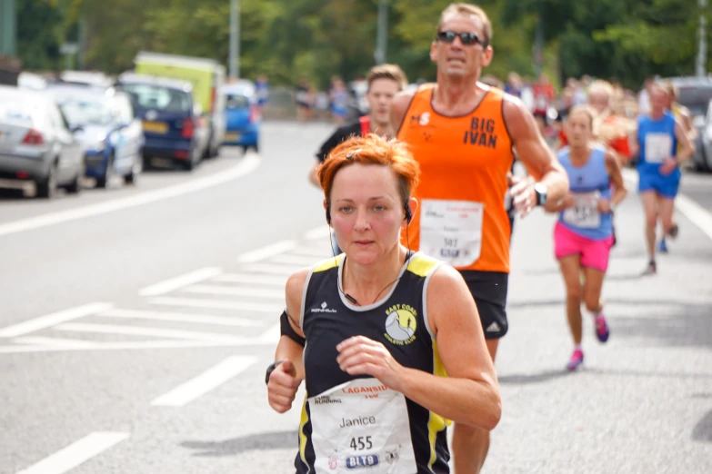 a woman running down the road with people watching her