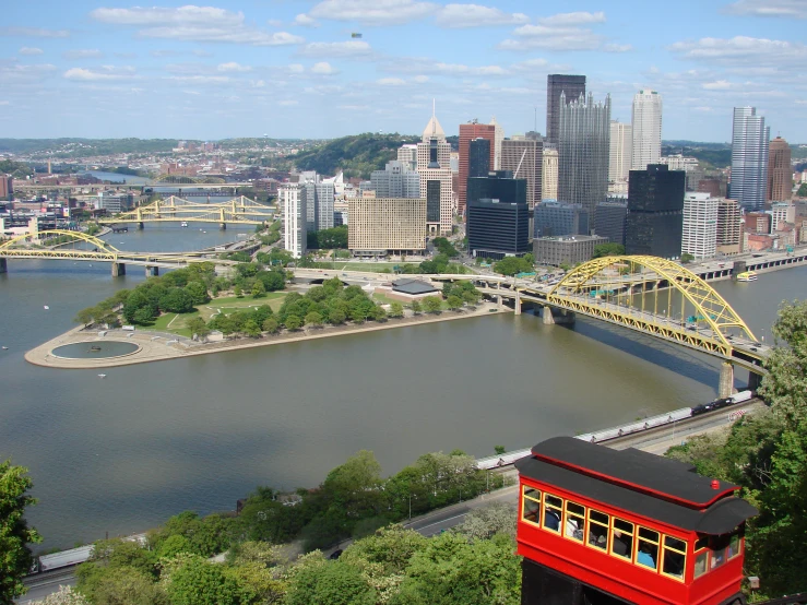 a yellow train going down the tracks over a river