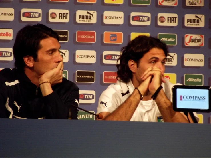 two men at a press conference looking off in the distance