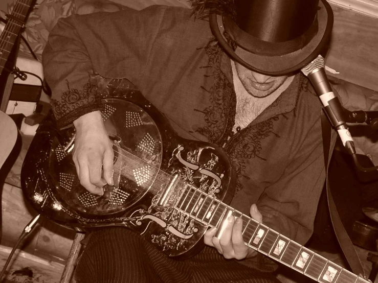 black and white image of man playing a guitar