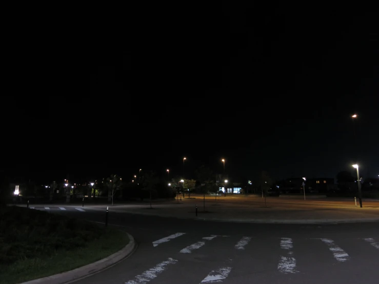 the night sky is black above the empty parking lot