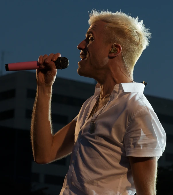 an older man is on stage singing into a microphone