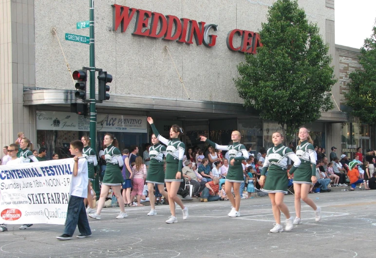 cheerleaders make their way through the streets for the wedding celetion