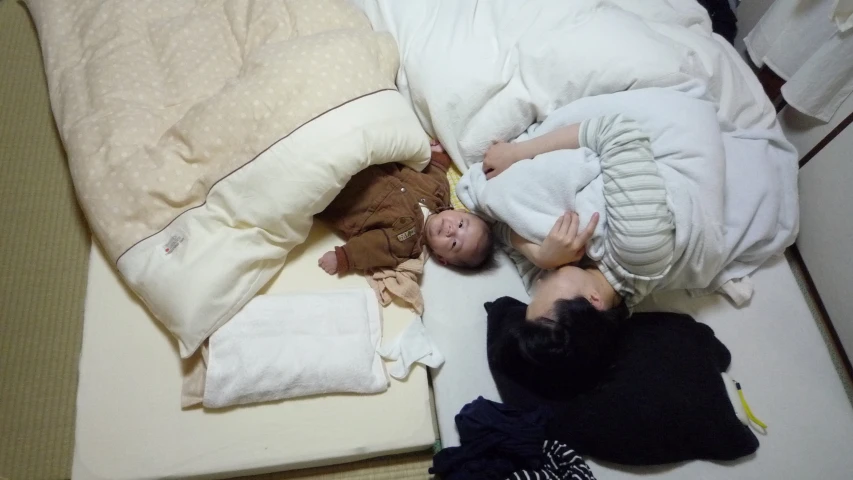 there is a sleeping baby on the bed