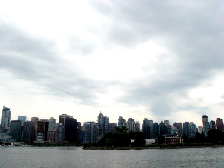 a city across the water under a cloudy sky