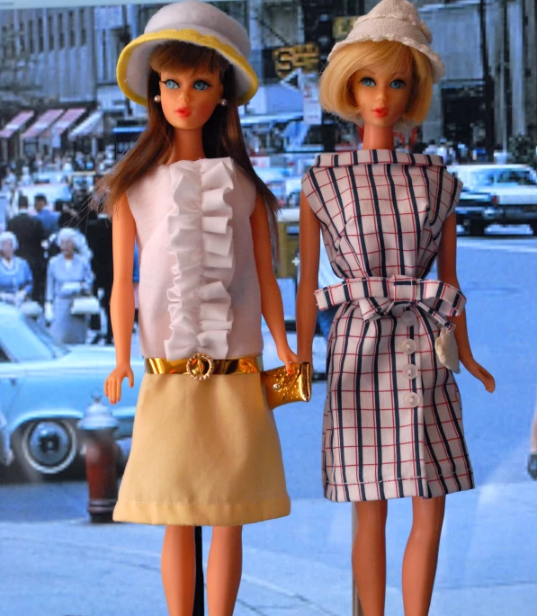 two dolls stand beside each other on a city street