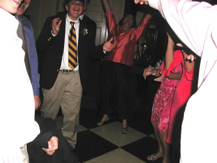 people are dancing at an event on a checkerboard floor