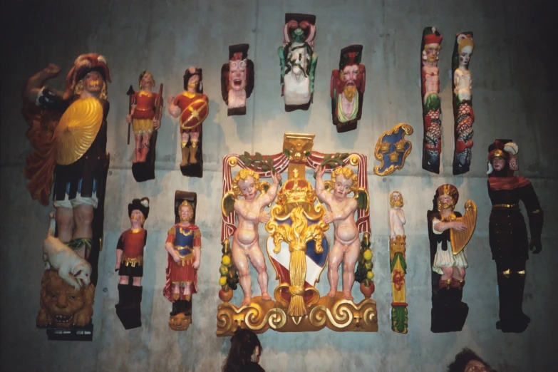 a colorful wall decorated with a variety of wooden figures