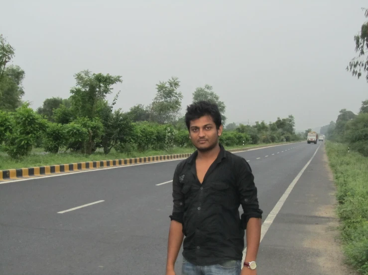 a man is standing on the side of the road in front of a truck