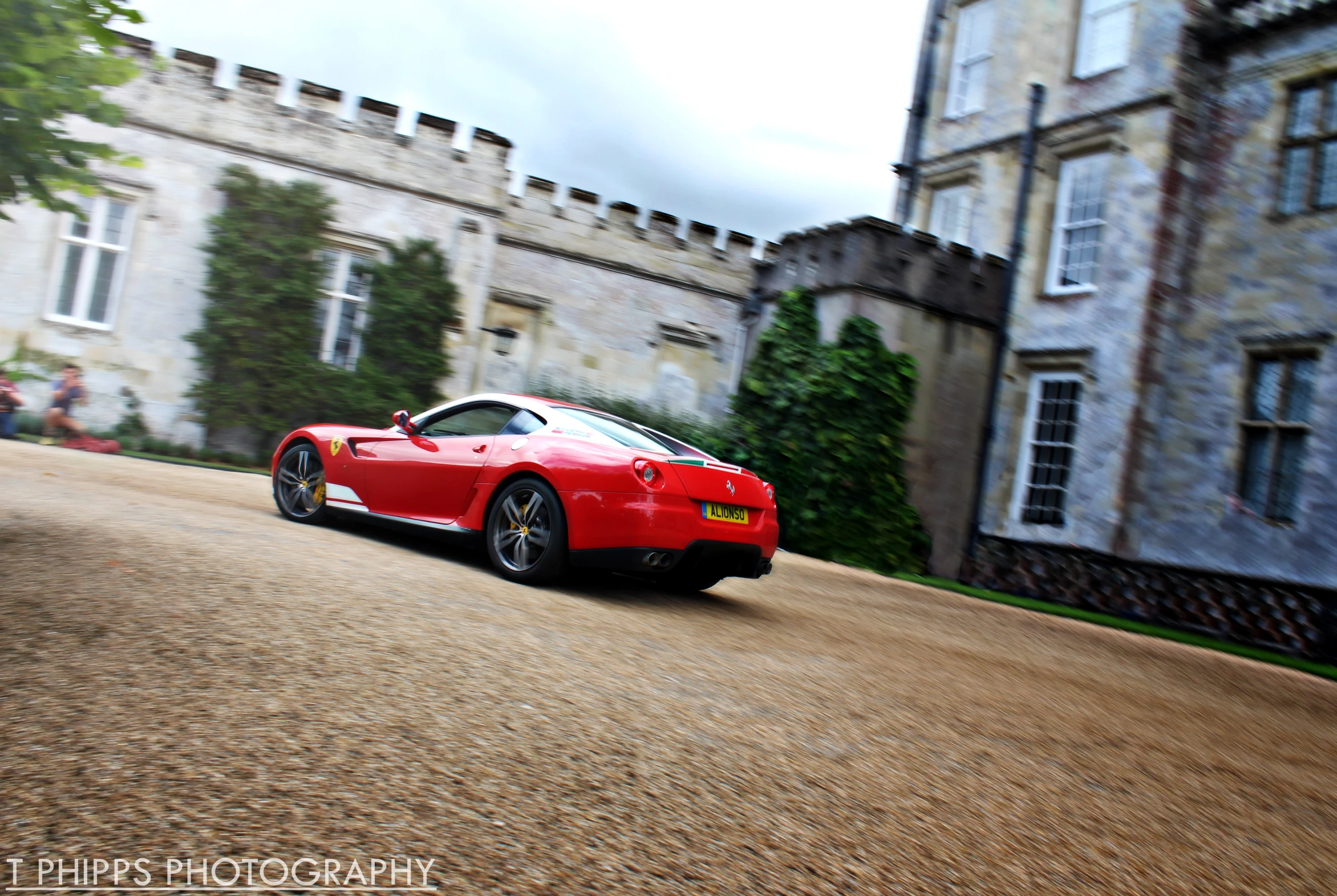 a red sports car driving in front of a castle