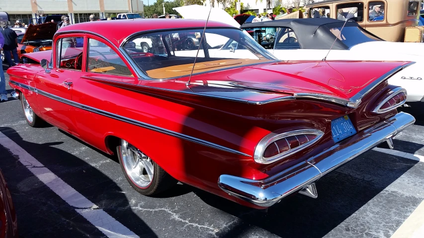 some red cars parked near other cars in a lot