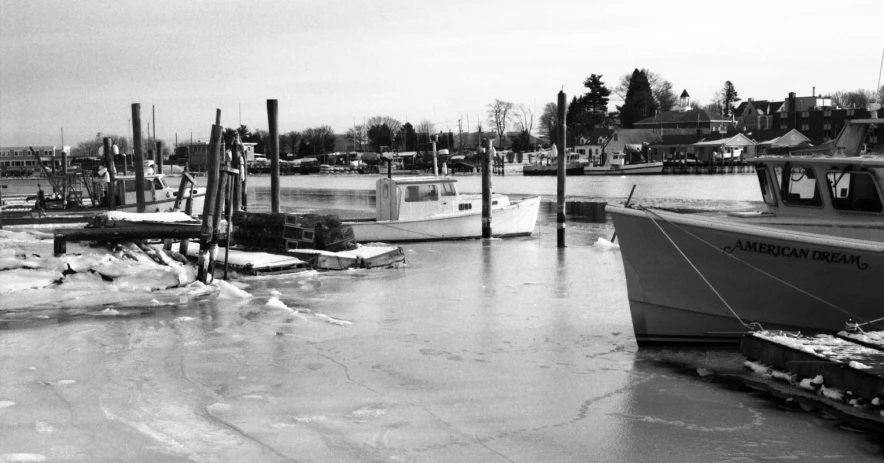 boats docked along an icy waterway on a gloomy day