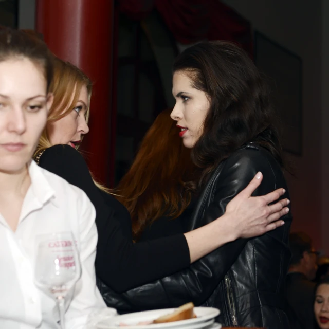 two women hugging at a table with plates on it