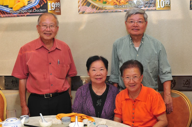 three asian men and two women sitting at a table