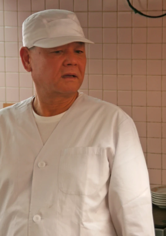 an elderly man in a white chef's coat and hat