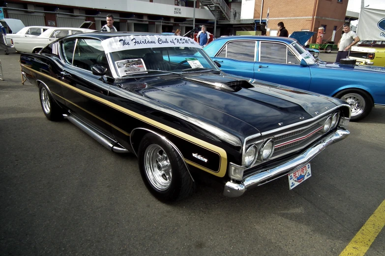 a couple of old classic cars parked in a parking lot