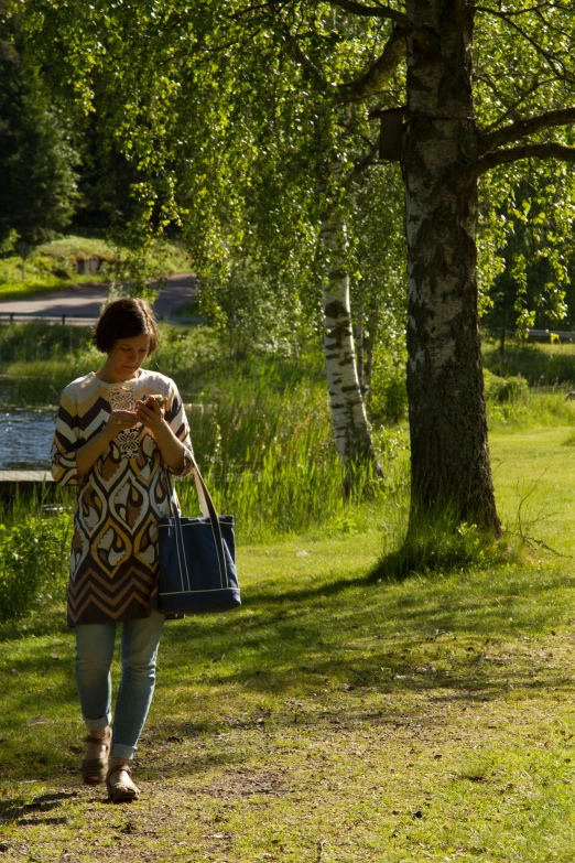 a woman walking along a grass covered path