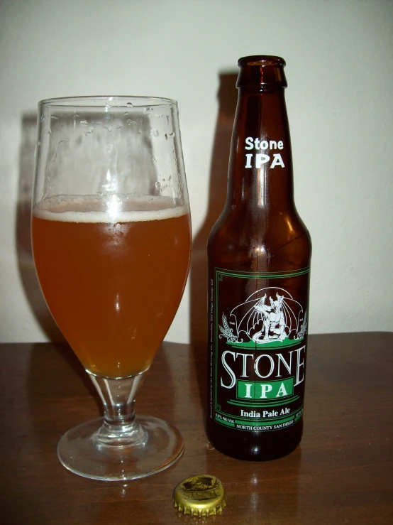 a bottle and glass sitting next to a bottle of stout