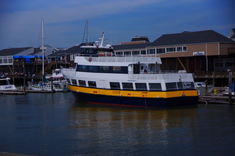 a boat floating next to a dock with houses on the other side of the water