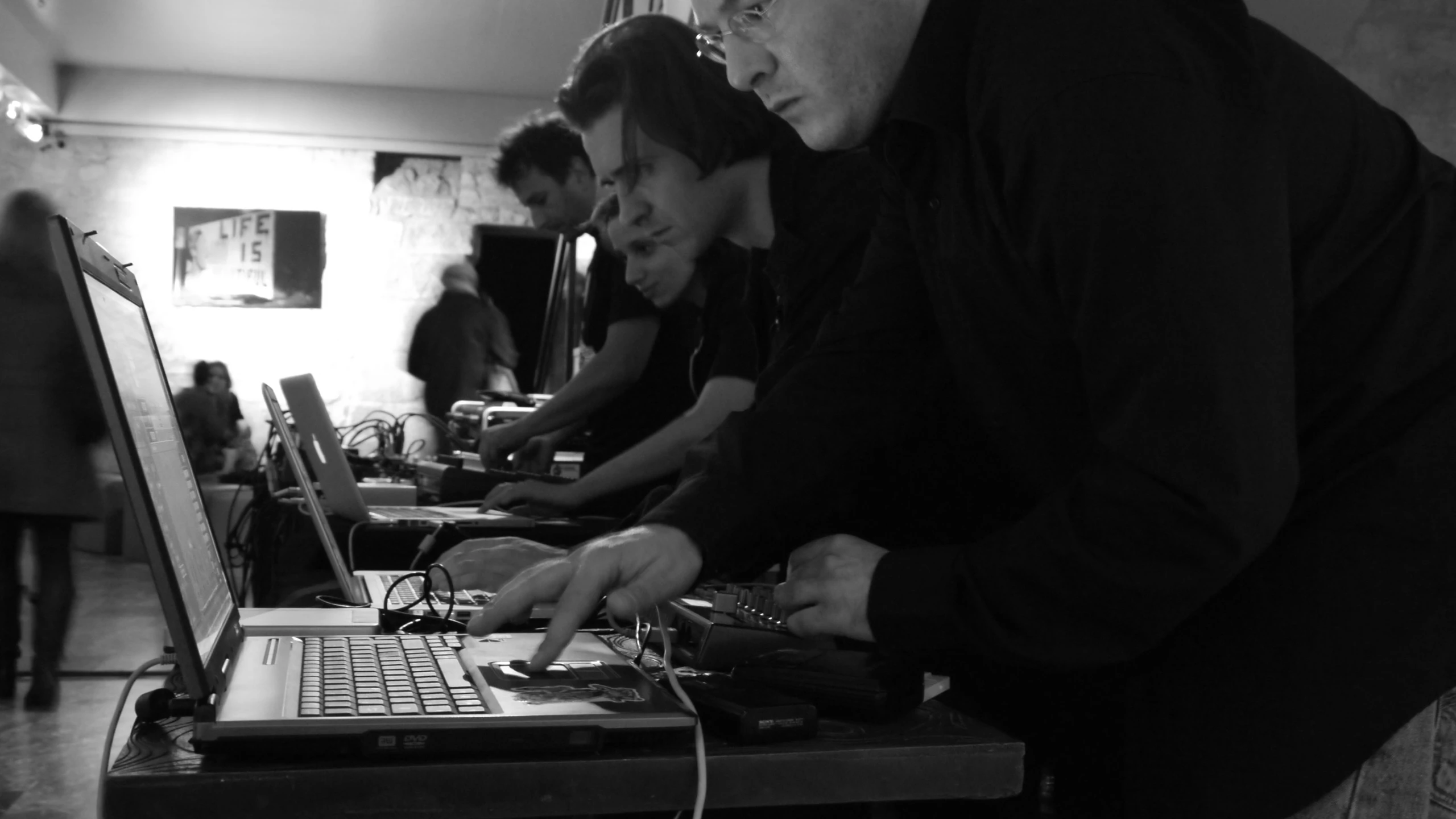a black and white po of three people in front of a laptop