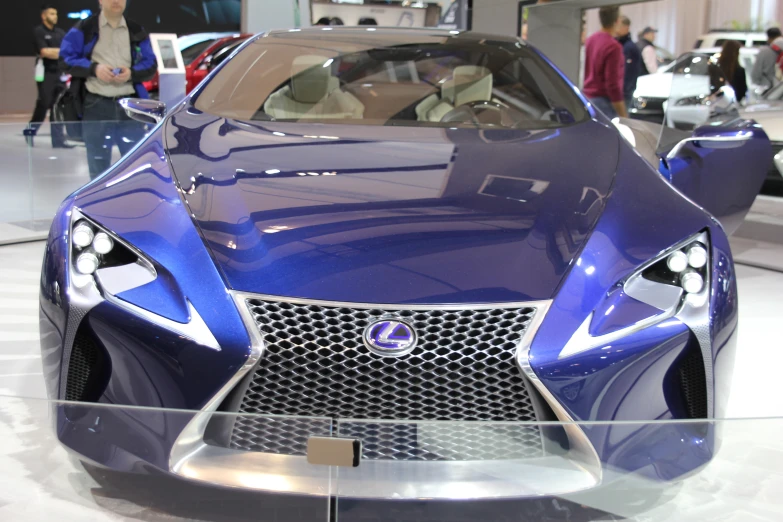 people looking at a new, futuristic car in a display