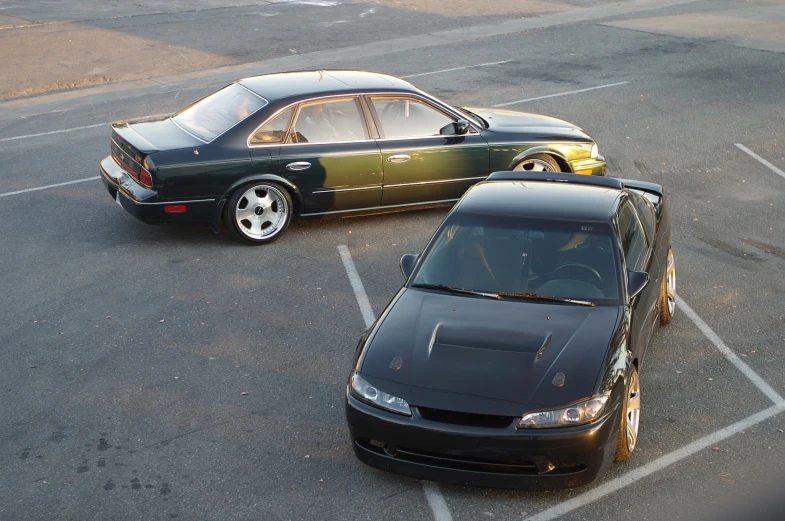 two black cars are parked in a parking lot