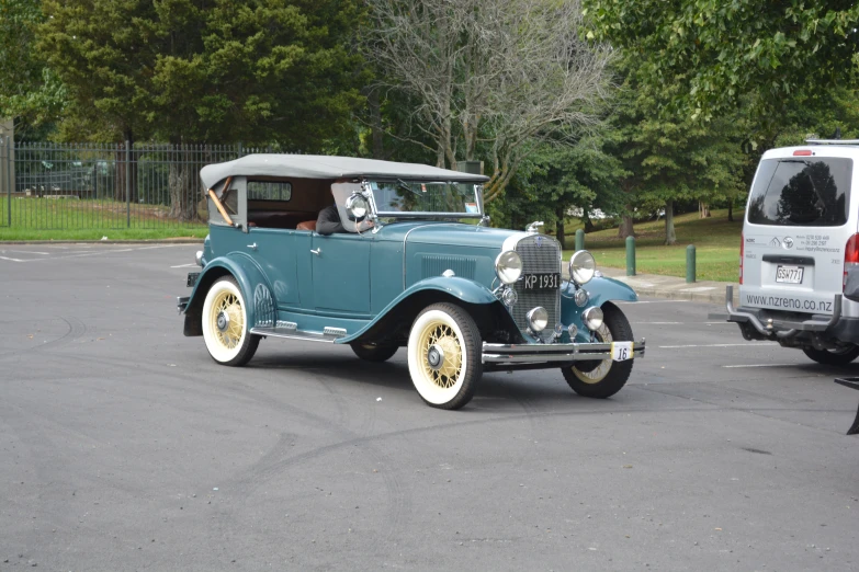 a classic car parked in a parking lot with other old cars