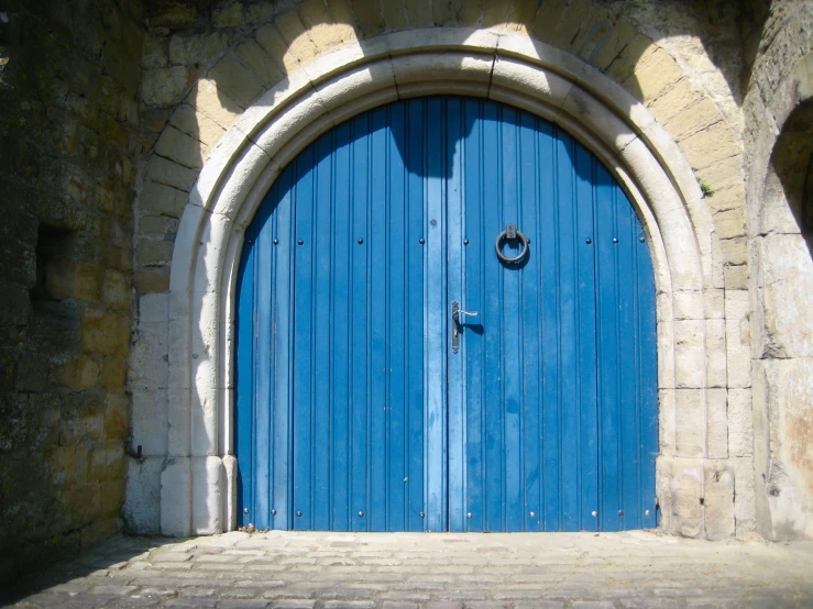 blue wooden doors with brick arch on side