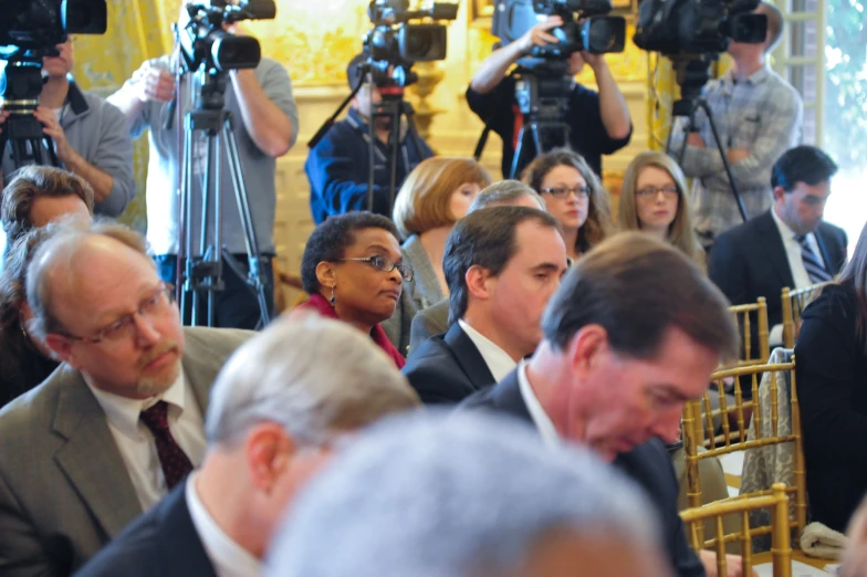 several people sitting and standing in front of the camera