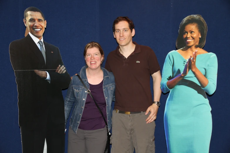 a group of people stand around a man with obama
