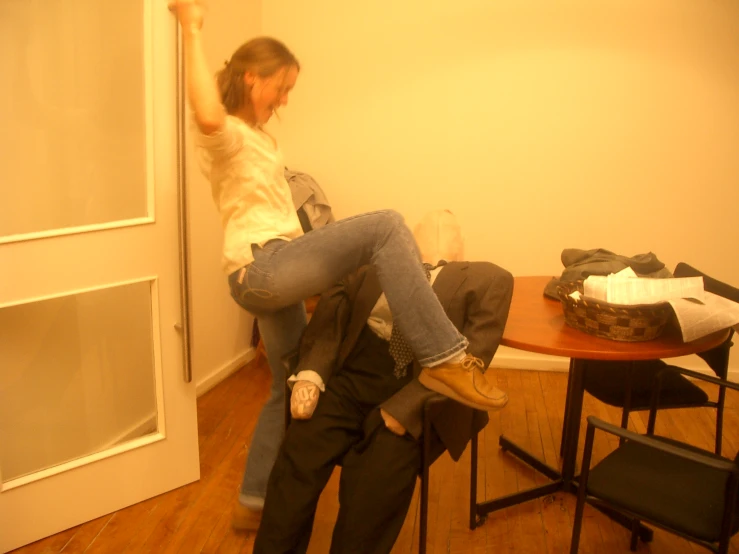 a woman sitting on a chair while holding onto someones leg