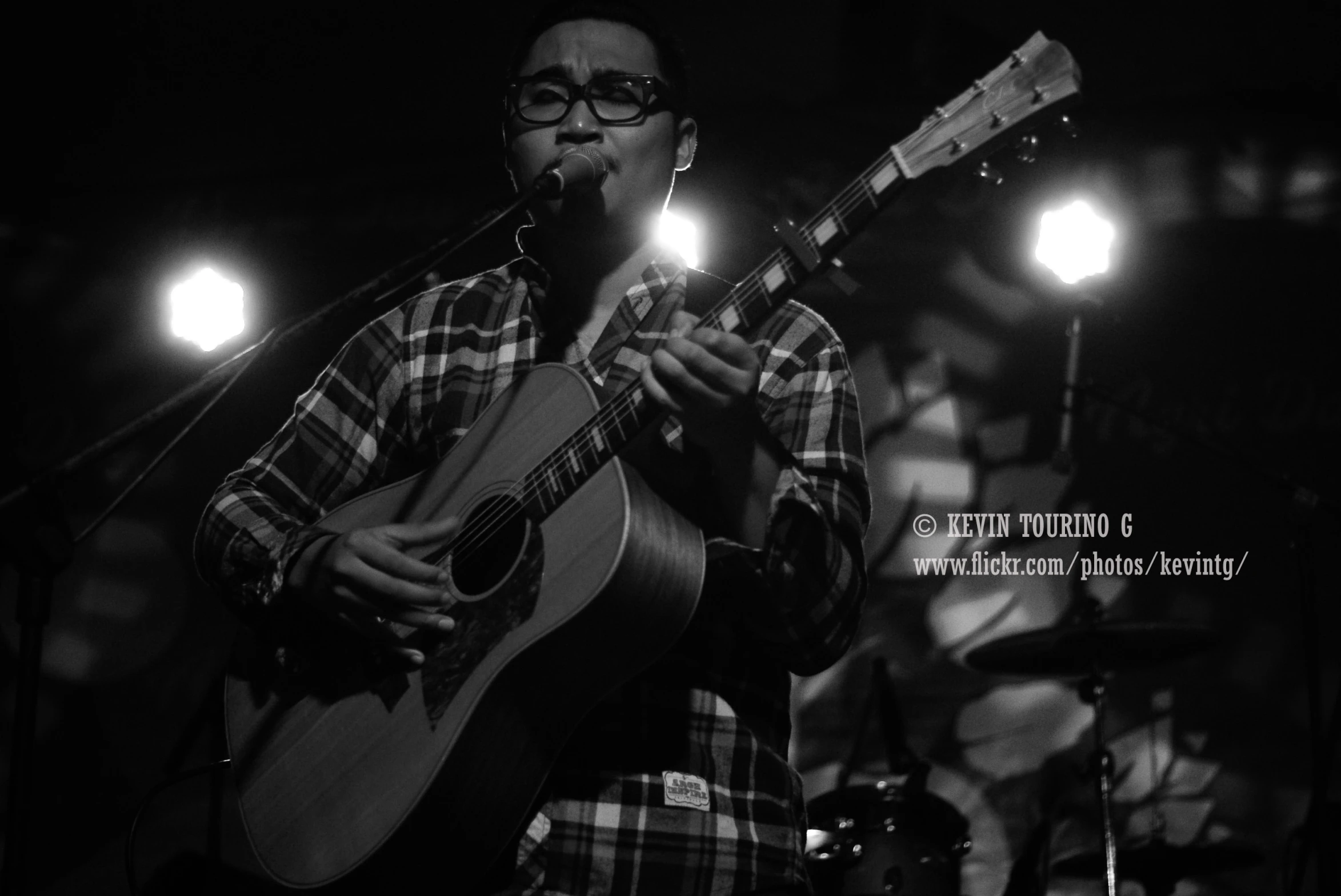 a man with glasses on holding a guitar