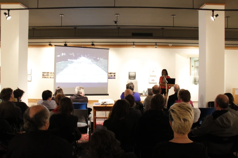 people are gathered around a large screen on the wall