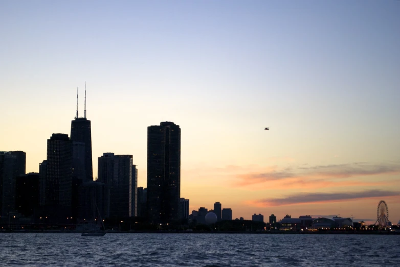 a large city is at night with a helicopter flying above