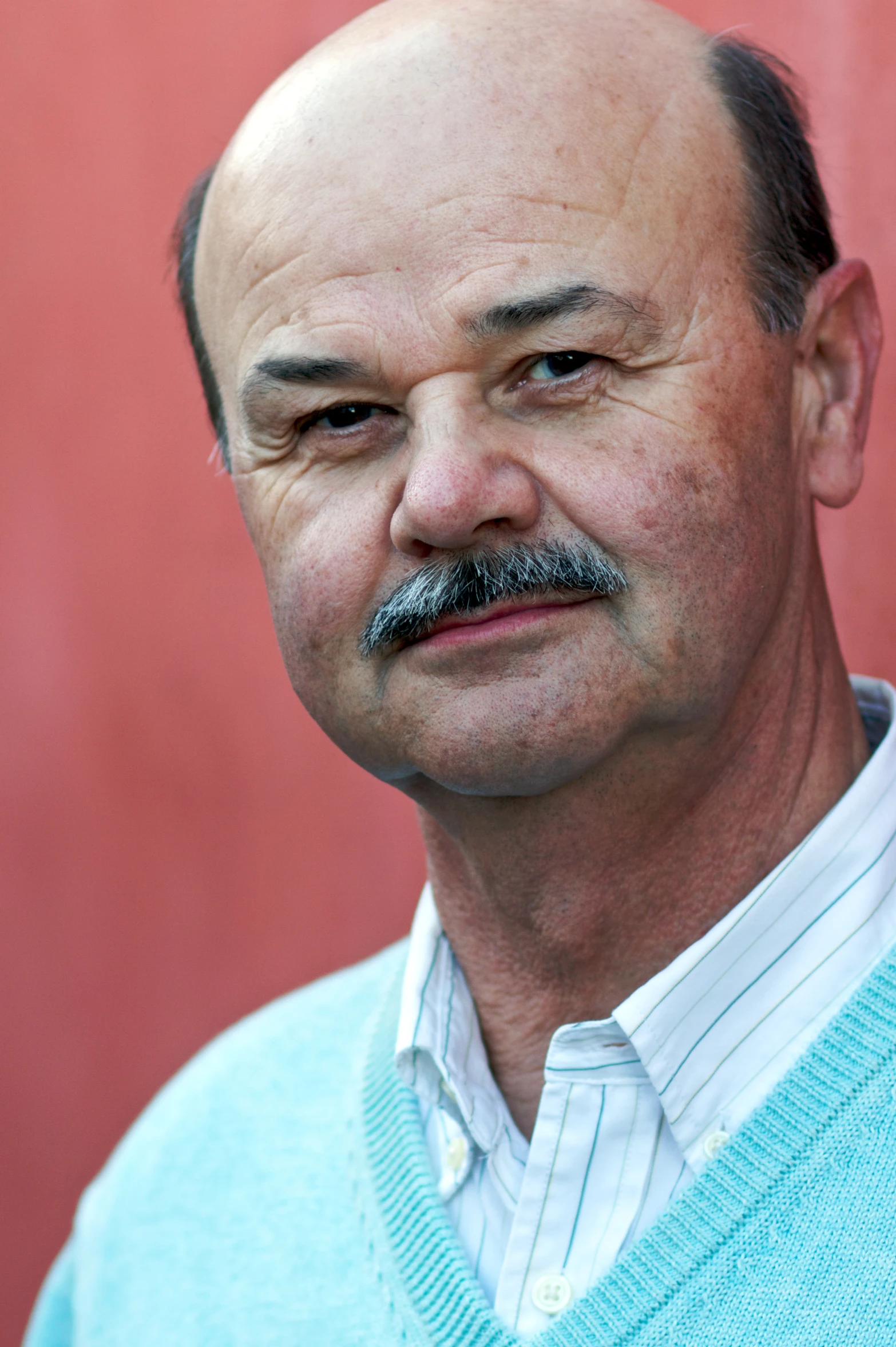 a man with a goatee mustache stares ahead