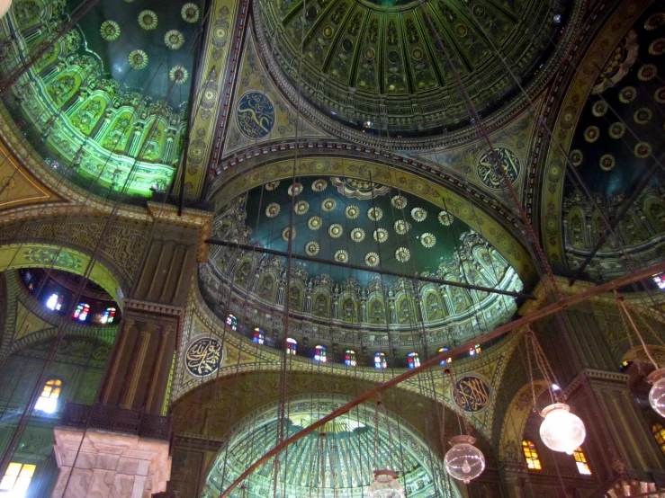 an overhead view of an ornate dome with chandeliers and glass mosaices