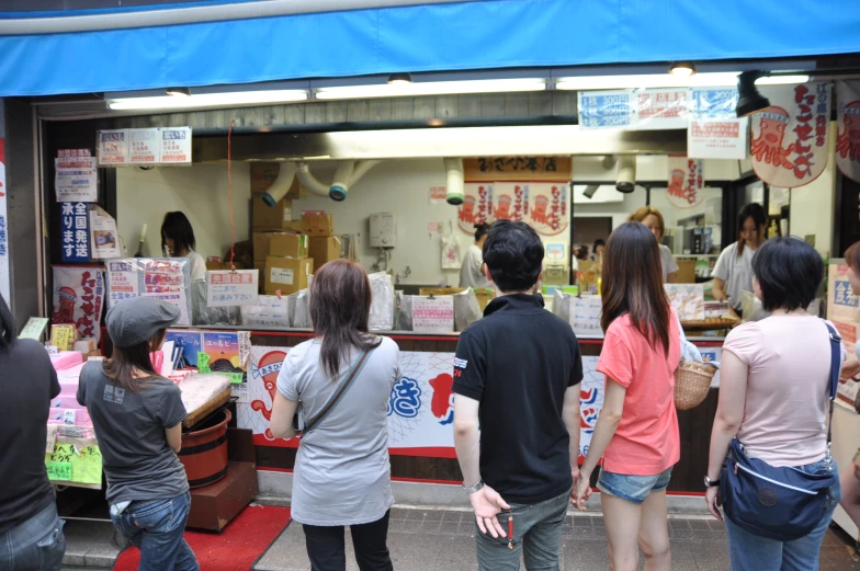 a number of people in front of a store